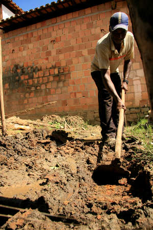 guaratinga, bahia, brazil - may 7, 2009: worker uses hoe to dig in land in the rural area of the city of Guaratinga, in southern Bahia.のeditorial素材