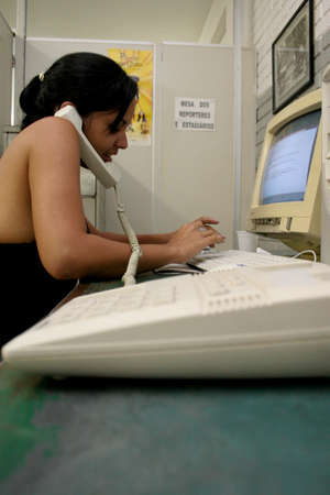 salvador, bahia / brazil - june 30, 2006: a person is seen using a fixed telephone in an office in the city of Salvador.のeditorial素材