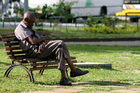 salvador, bahia / brazil - august 23, 2006: elderly man is seen napping on a garden bench in the city of Salvador.のeditorial素材