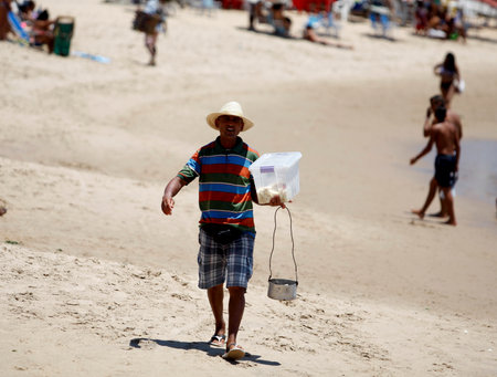 salvador, bahia / brazil - december 30, 2015: Street vendor is seen at Praia do Flamengo in the city of Salvador.のeditorial素材