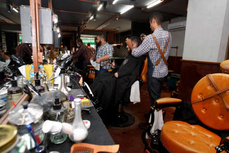 salvador, bahia / brazil - july 1. 2018: barber is seen working in a barber shop in the city of salvasdor.のeditorial素材