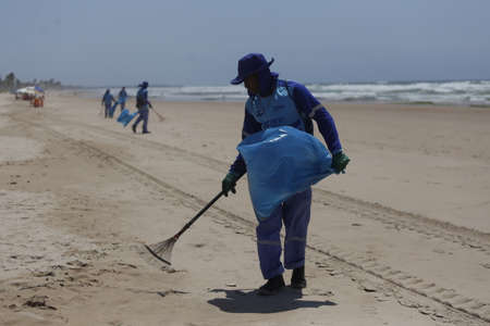 salvador, bahia / brazil - October 12, 2019: Public cleaners are seen collecting oil slicks on Ipitanga beach due to oil spill into the sea.のeditorial素材