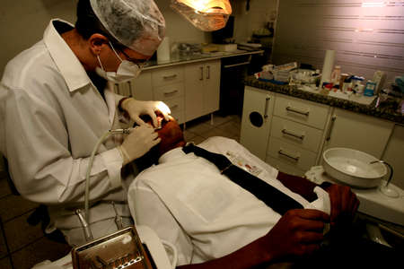 eunapolis, bahia / brazil - october 27, 2010: dentist is seen undergoing treatment on a patient in a dental office in the city of Eunapolis.のeditorial素材