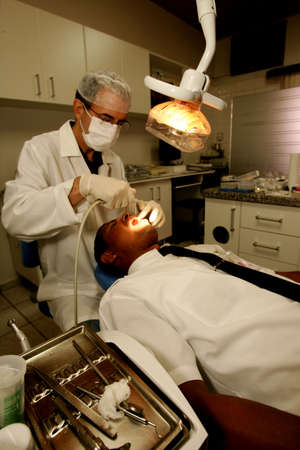eunapolis, bahia / brazil - october 27, 2010: dentist is seen undergoing treatment on a patient in a dental office in the city of Eunapolis.のeditorial素材