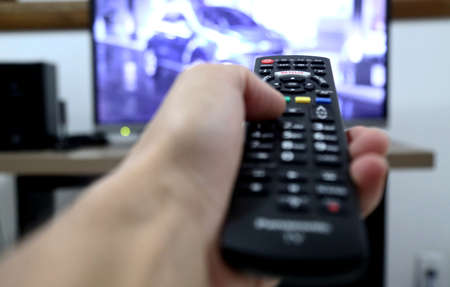 salvador, bahia / brazil - october 18, 2014: hand holding remote control of LCD television in the city of Salvador.のeditorial素材
