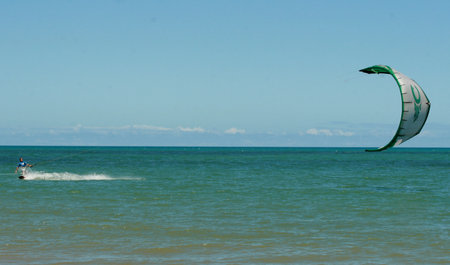 Porto Seguro, Bahia, Brazil - March 5, 2009: Kitesurfing practitioner is seen sailing with his kite and board on the beach in the city of Porto Seguro.のeditorial素材