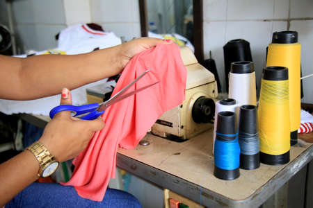 Salvador, Bahia, Brazil - July 6, 2021: Woman works with a sewing machine at a workshop in the city of Salvador.のeditorial素材
