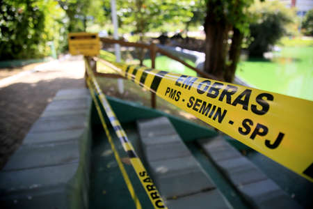 salvador, bahia, brazil - july 20, 2021: striped protective tape to isolate an area to prevent crowding of people in a park in the city of Salvador.のeditorial素材