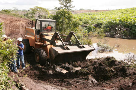 Porto Seguro, Bahia, Brazil - April 20, 2010: Tractor is seen working in a flooded area for land...