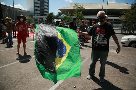 salvador, bahia, brazil - september 7, 2021: protester carries a Brazilian flag during a demonstration against president Jair Bolsonaro in the city of Salvador.のeditorial素材