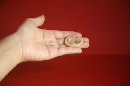 Salvador, Bahia, Brazil - November 14, 2021: Person holding a male condom in Salvador city.の写真素材