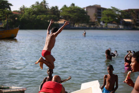 lauro de freitas, bahia, brazil - november 20, 2017: children bathing in the water of the river Joanes in the region of Lauro de Freitas. the river receives domestic sewage from the metropolitan region of Salvador.のeditorial素材