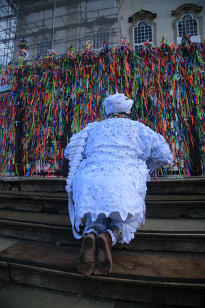 Salvador, Bahia, Brazil - January 13, 2022: adept of the Candomble religion visiting the steps of...