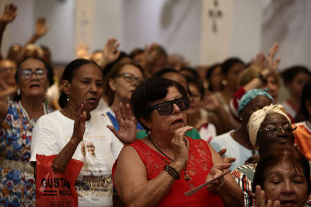 salvador, bahia, brazil - september 27, 2017: Devotees of saints Sao Cosme and Sao Damiao attend mass in praise of the twin saints in Liberdade neighborhood in Salvador.のeditorial素材