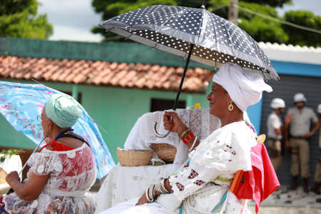 Salvador, Bahia, Brazil - January 25, 2015: devotee of candomble religion seen in front of the catholic church of Sao Lazaro in the city of Salvador.のeditorial素材