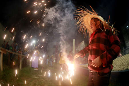 salvador, bahia, brazil - june 11, 2022: a child releasing fireworks during a party in honor of...