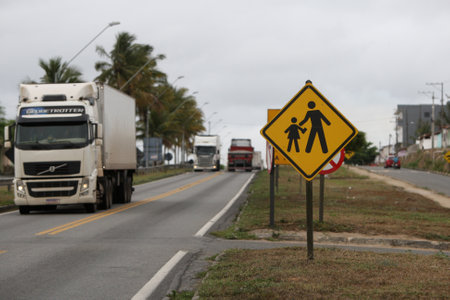 jaguaquara, bahia, brazil - october 14, 2022: traffic sign indicates school area and children crossing the BR 116 highway in the city of Jaguaquara.のeditorial素材