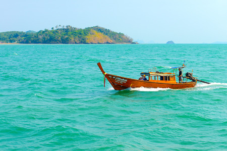 PHUKET, THAILAND - MARCH 24, 2015: Tourists traveling by Long tail boat on blue water of Andaman Sea in summer at Phuket island. - 24 March 2015, Phuket , Thailand.のeditorial素材