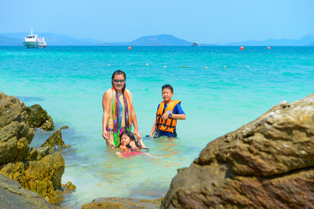 Mother and children relaxing, Shooting photo, having fun on the beach in summer at Khai Nok island, Phang Nga, Thailandの写真素材