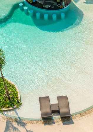 Beach chairs and The bar counter in luxury swimming pool at tropical hotel resort, relaxing and leisure time in the pool. Top view.の写真素材