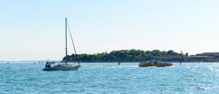 View of street at the Grand Canal on a hot summer morning. Blue sky, azure water, beautiful architecture of Venice, Italy.の写真素材