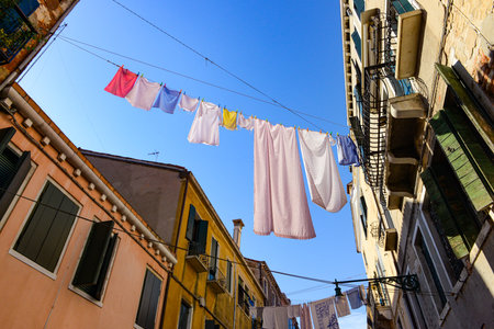 Typical city corner with ancient colorful buildings Drying clothes on a clothes-line in outdoor at sunny summer day. Venice, Italyの写真素材