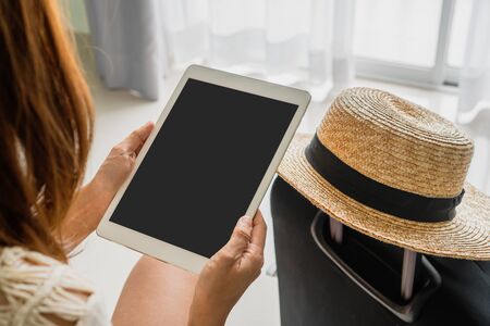 Women sitting on bed using tablet in the hotel.の写真素材