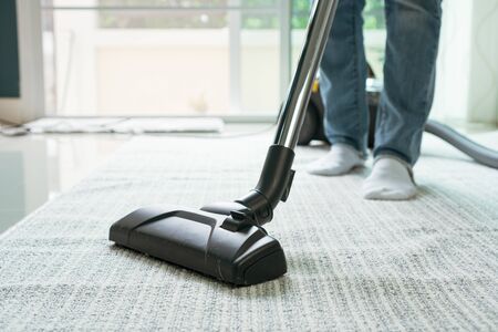 Women using vacuum cleaner cleaning carpet in the living room .の写真素材