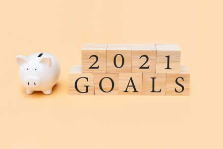 Closeup of 2021 Goals and piggy bank on beige background. New year planning or 2021 plan concept....