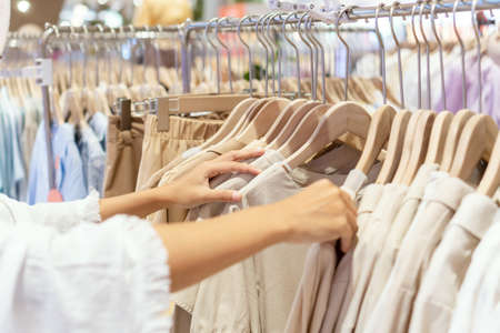 Young Asian woman choosing clothes in department store. Close upの写真素材