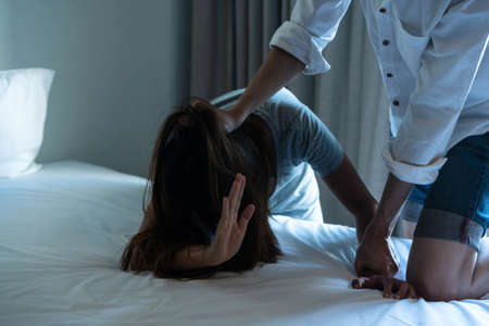 Frightened crying young Asian woman suffering from aggressive man behavior. Domestic abuse, stop violence and rape conceptの写真素材