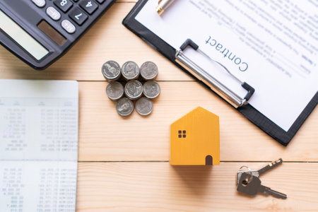 Top view of model home, bank book, money, paper work and calculator on a wooden table. Account, loan, collect money and investments concept. Flat layの写真素材