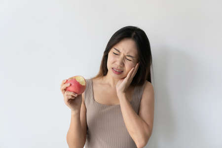 Asian woman feeling teeth pain. Closeup of sad girl suffering from toothache. Beautiful female...