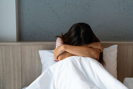 Teenager girl with depression sitting alone on bed.  sad, unhappy, disappointed concept