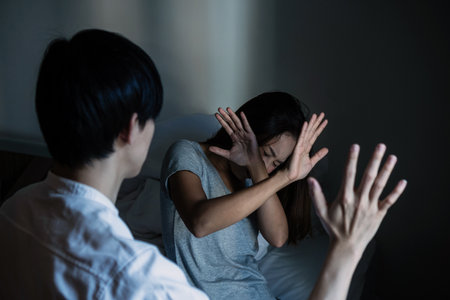 Frightened crying young Asian woman suffering from aggressive man behavior. Domestic abuse, stop violence and rape concept. International Women's Dayの写真素材