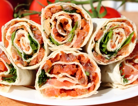 rolls filled with smoked salmon, cheese, lemon, tomato, dill and parsley in lavashの写真素材