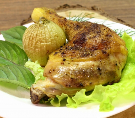 fried chicken quarter with the fried onions, basil and lettuce leavesの写真素材