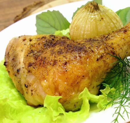 fried chicken quarter with the fried onions, basil and lettuce leavesの写真素材