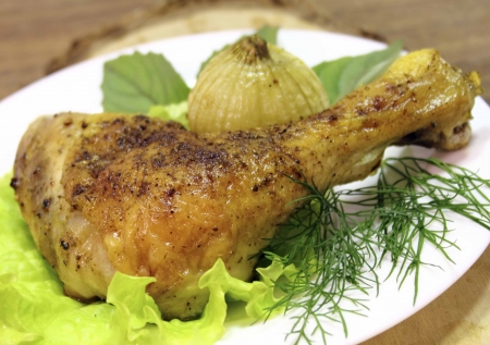 fried chicken quarter with the fried onions, basil and lettuce leavesの写真素材