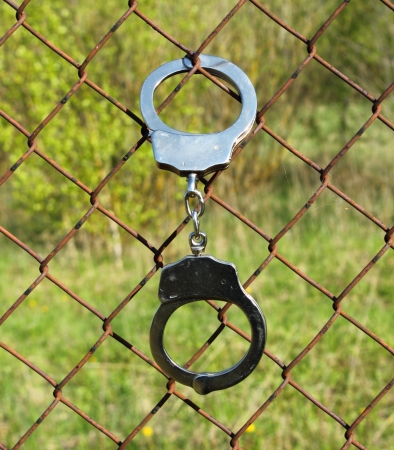lock in handcuffs to the fence symbolizes captivity の写真素材