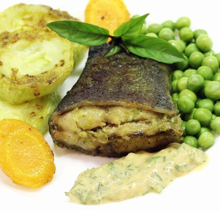 this is the fried fish with grilled zucchini and carrotsの写真素材