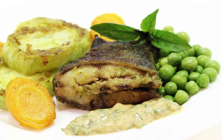 this is the fried fish with grilled zucchini and carrotsの写真素材