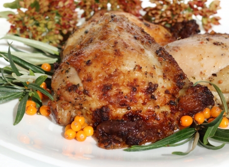 it is fried chicken thighs with sea-buckthorn on a white plate の写真素材