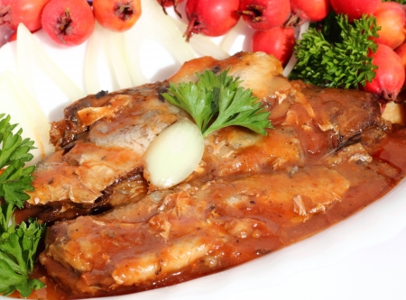 sprats in tomato sauce with onions on a white plate の写真素材