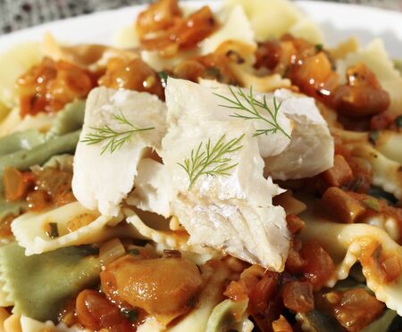 Smoked fish fillet served with pasta and sauce with mushroomsの写真素材