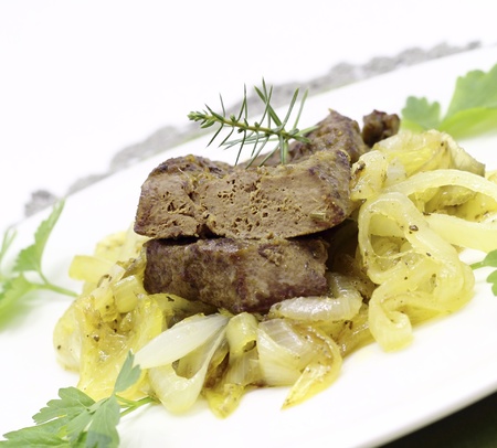 Fried pork liver with caramelized onions a white plateの写真素材
