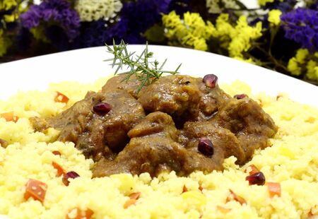 Mutton stew served with couscous, peppers zucchini cubes and pomegranate seedsの写真素材