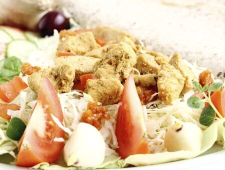 Fried sliced chicken breast served with vegetables and tortillaの写真素材