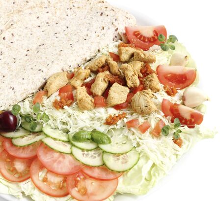 Fried sliced chicken breast served with chopped vegetables and tortilla leaves の写真素材