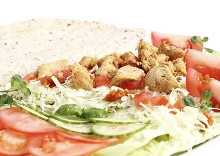 Fried savory chicken breast slices  with vegetables and tortilla on a white backgroundの写真素材